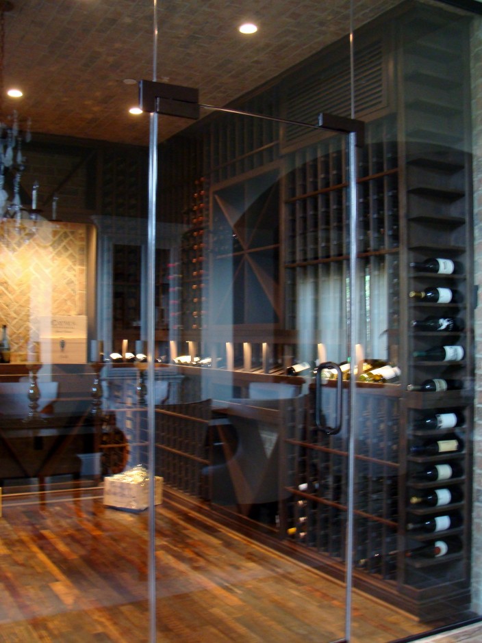 Seamless Glass Wine Cellar Door Provides a Clear View of the Wine Display in an Orange County Home