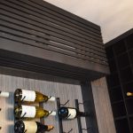 We cover all our cooling units in a custom-made grille so they still look aesthetic wherever we install them inside a glass wine cellar in Orange County.