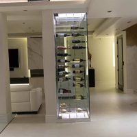 Add a luxurious appeal to your wine collection with this modern cable wine display system for your wine closet. Home Living Room with a Centered Glass Wine Cellar