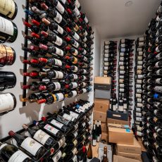 (5) Looking for high-capacity modern wine cellar ideas? This design packs hundreds of bottles into a sleek layout using triple-deep wall-mounted racks and precise lighting.