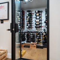 (3) Tempered glass doors elevate the look of this space, making it a prime example of modern wine cellar ideas for luxury homes—form meets function in one elegant entryway.